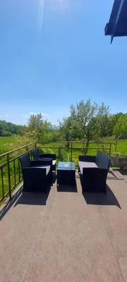 a group of couches and tables on a patio at Podgozd Holiday House in Trnovo