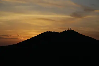 a hill with a lighthouse on top of it at sunset at Podgozd Holiday House in Trnovo