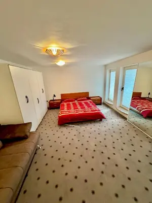 a bedroom with a red bed and a couch at Vila Giovana in Vipava