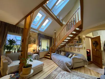 a large room with a staircase and a living room at Unique apartma in the city center in Ljubljana