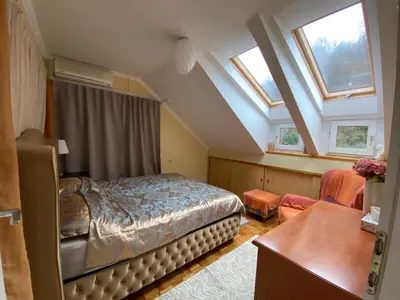 a bedroom with a bed and a desk and windows at Unique apartma in the city center in Ljubljana