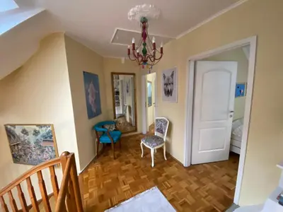 a living room with a staircase and a chandelier at Unique apartma in the city center in Ljubljana