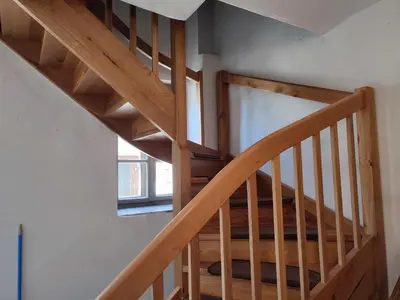 a wooden staircase in a house with a window at Apartmaji Stara Šola in Bohinjska Bistrica