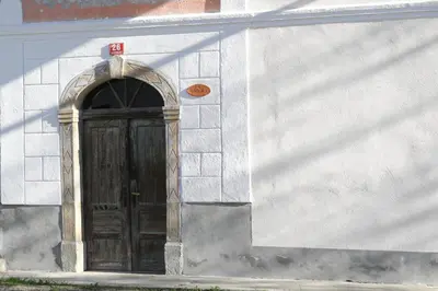 a wooden door on a white building with an arch at Apartmaji Stara Šola in Bohinjska Bistrica