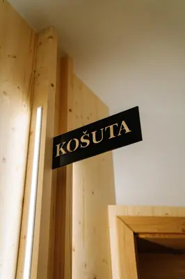 a sign that says kosciuszko on a wooden wall at Sobe rooms JELEN JELENOV GREBEN in Podčetrtek