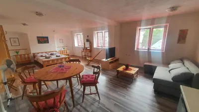 a living room with a table and a couch at Idiličen apartma in Kamna Gorica