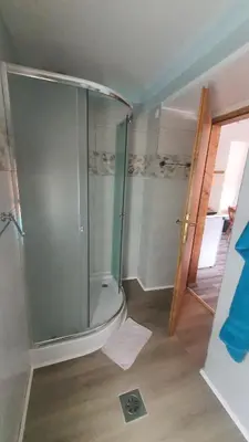 a bathroom with a shower with a glass door at Idiličen apartma in Kamna Gorica