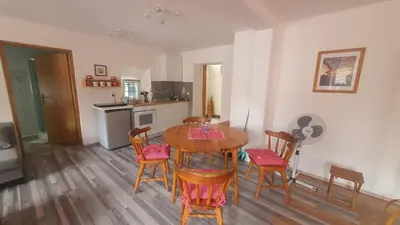 a kitchen and dining room with a table and chairs at Idiličen apartma in Kamna Gorica