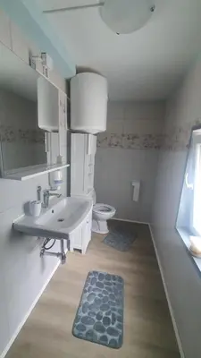 a white bathroom with a sink and a toilet at Idiličen apartma in Kamna Gorica
