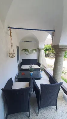 a patio with couches and a table and chairs at Idiličen apartma in Kamna Gorica