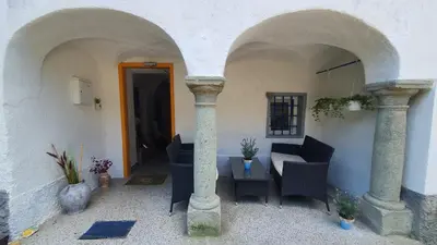 a patio with chairs and a table in a building at Idiličen apartma in Kamna Gorica