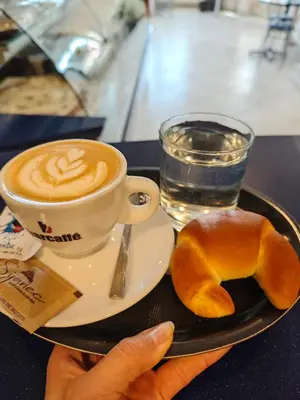 a plate with a cup of coffee and a pastry at Wellness soba Amaris in Benedikt v Slovenskih Goricah