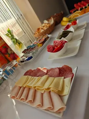 a table topped with cheese and meats on plates at Wellness soba Amaris in Benedikt v Slovenskih Goricah