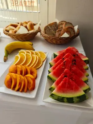 a table with three plates of fruit and baskets of bread at Wellness soba Amaris in Benedikt v Slovenskih Goricah