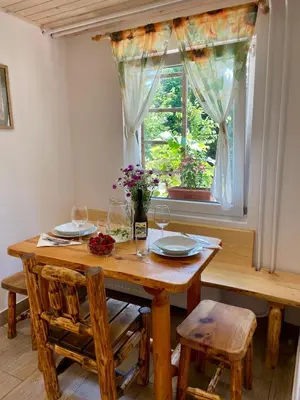 a dining room table with chairs and a window at The Wood Nest Apartment in Borovnica