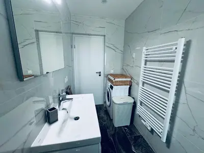 a white bathroom with a sink and a mirror at Rebecca's Apartment in Radovljica