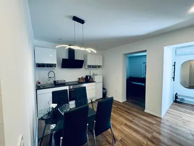 a kitchen and dining room with a glass table and chairs at Rebecca's Apartment in Radovljica