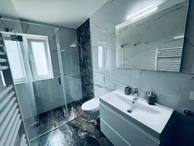 a white bathroom with a sink and a mirror at Rebecca's Apartment in Radovljica