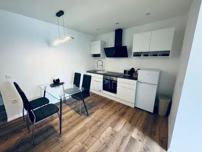 a kitchen with a table and chairs and a refrigerator at Rebecca's Apartment in Radovljica