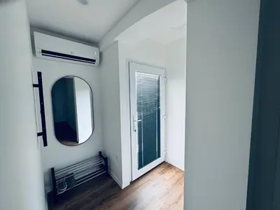 a white room with a mirror and a window at Rebecca's Apartment in Radovljica