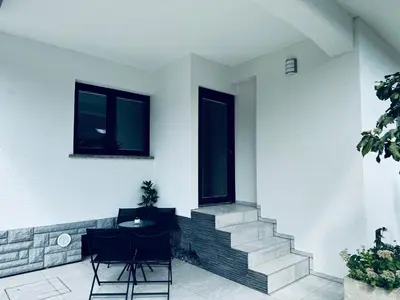 a room with two windows and a table and chairs at Rebecca's Apartment in Radovljica