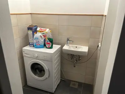 a small bathroom with a washing machine and a sink at Apartment Pr`Jurčk Bled in Bled