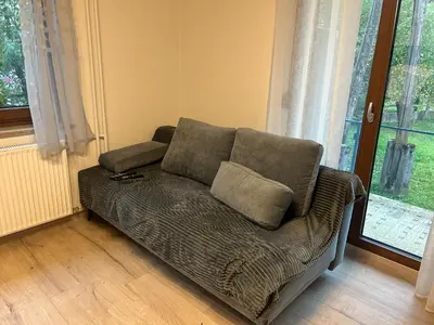 a couch sitting in a living room next to a window at Apartment Pr`Jurčk Bled in Bled