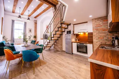 a kitchen and living room with a table and chairs at The LOFT Ljubljana in Ljubljana