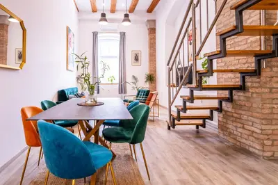 a dining room with a table and chairs and a staircase at The LOFT Ljubljana in Ljubljana