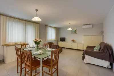a dining room and living room with a table and chairs at Cesar's Karst Estate in Sežana