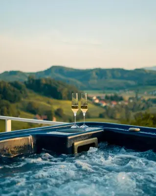 two glasses of wine in a hot tub at Cottage Retreat with Hot Tub & Sauna in Zgornja Kungota