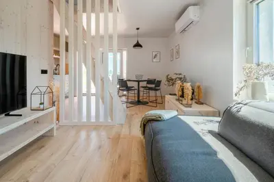 a living room with a bed and a dining room at Cottage Retreat with Hot Tub & Sauna in Zgornja Kungota