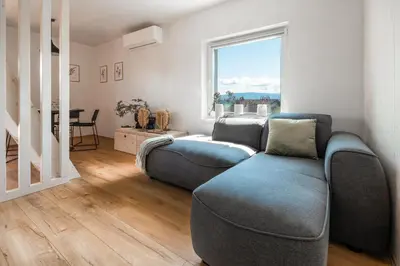a living room with a couch and a window at Cottage Retreat with Hot Tub & Sauna in Zgornja Kungota