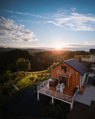 an aerial view of a cabin with the sun setting at Cottage Retreat with Hot Tub & Sauna in Zgornja Kungota