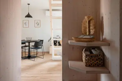 a living room with wooden shelves and a table at Cottage Retreat with Hot Tub & Sauna in Zgornja Kungota