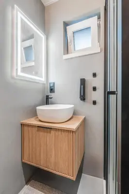 a bathroom with a white sink and two windows at Cottage Retreat with Hot Tub & Sauna in Zgornja Kungota
