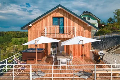 a house with two white umbrellas in front of it at Cottage Retreat with Hot Tub & Sauna in Zgornja Kungota
