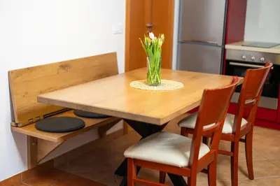 a dining room table with a vase of flowers on it at Apartment Markič in Bohinj