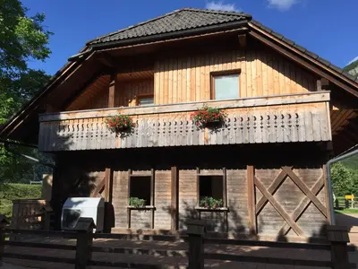 a large wooden house with two windows and a balcony at Apartment Markič in Bohinj