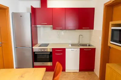 a kitchen with red cabinets and a sink at Apartment Markič in Bohinj