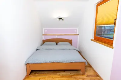 a small bed in a small room with a window at Apartment Markič in Bohinj