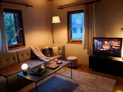 a living room with a couch and a tv at Ski Cottage in Semič