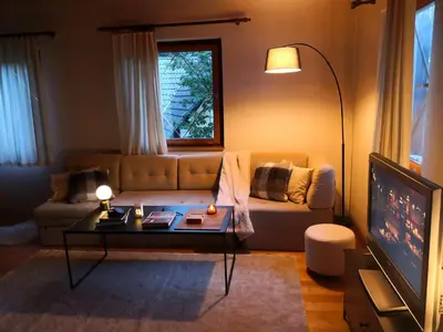 a living room with a couch and a table at Ski Cottage in Semič