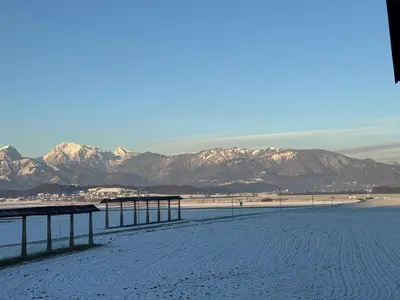 a snowy beach with mountains in the background at Mojca's nest apartment in Mengeš