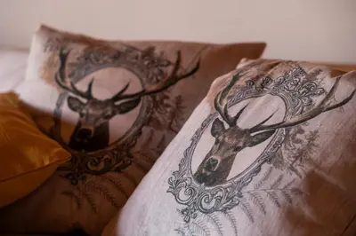 a pillow with a picture of a deer head on it at Wellness hiša Jelenov Grič in Mala Nedelja