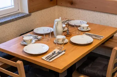 a wooden table with plates and wine glasses on it at 4 TeTE in Vrhpolje