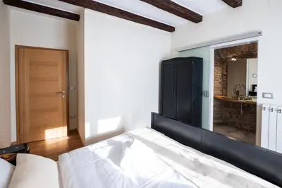 a bedroom with a white bed and a kitchen at 4 TeTE in Vrhpolje