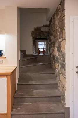 a staircase in a house with a stone wall at 4 TeTE in Vrhpolje