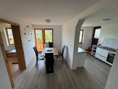 a kitchen and dining room with a table and chairs at Apartma Petra in Selca