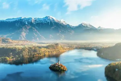 an island in the middle of a lake with mountains at Apartma Petra in Selca
